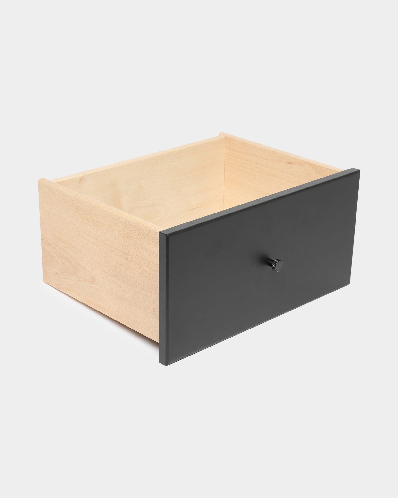 WoodUpp Arka zwarte boekenkast met lade en ronde knop, geschikt voor gesloten opbergruimte, afgebeeld tegen een effen witte achtergrond.